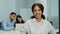 Portrait smiling attractive businesswoman sitting in modern business office with multicultural professionals team