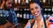 Portrait of smiling barmaid with barman in background