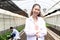 Portrait of smiling beautiful Asian botanist scientist woman in white lab coat standing with arms crossed. Female biological