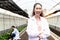 Portrait of smiling beautiful Asian botanist scientist woman in white lab coat standing with arms crossed. Female biological