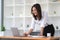 Portrait of smiling beautiful Asian businesswoman enjoy the idea sitting with laptop computer at office.