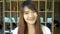 Portrait of smiling beautiful asian student standing in library. Bookcase bookshelves in background