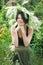 Portrait of a smiling beautiful girl in wreath flowers and herbs on the meadow sunny day. young Slavic woman