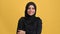 Portrait smiling beautiful Muslim woman in black hijab posing isolated on orange studio closeup