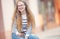 Portrait of a smiling beautiful teenage girl with dental braces. Young schoolgirl with school bag and mobile phone