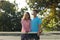 Portrait of smiling biracial couple playing tennis embracing on sunny outdoor tennis court