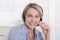 Portrait of smiling blond mature woman working with headphone.