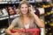 Portrait of smiling blonde woman buying vegetables and phoning