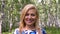 Portrait smiling blonde woman in summer birch grove close up