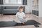 Portrait of smiling boy child on yoga meditation session, sitting in Padmasana exercise, Lotus pose with Namaste, working out.