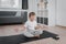 Portrait of smiling boy child on yoga meditation session, sitting in Padmasana exercise, Lotus pose with Namaste, working out.
