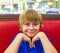 Portrait of smiling boy sitting on a red bench