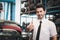 Portrait of smiling businessman seller standing and giving thumb up at auto spare parts store shop warehouse with many second hand
