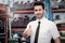 Portrait of smiling businessman seller standing and giving thumb up at auto spare parts store shop warehouse with many second hand