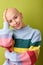 Portrait of smiling caucasian bald female in bright colorful shirt touching head