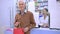 Portrait of smiling Caucasian grey-haired man posing with shopping bag at cash desk in pharmacy leaving. Satisfied