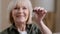 Portrait smiling Caucasian old senior woman female elderly owner seller householder posing in new home showing key from