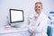 Portrait of smiling dentist working while sitting by computer