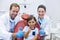 Portrait of smiling dentists and young patient showing thumbs up