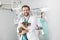 Portrait of smiling doctor carrying cat while standing against coworker at veterinary clinic