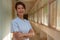 Portrait of smiling elder Nurse standing at hospital balcony