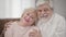 Portrait of smiling elderly Caucasian spouses looking at camera. Joyful mature husband and wife posing indoors