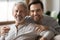 Portrait of smiling elderly father with adult son