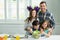 Portrait of smiling family preparing bowl of salad in kitchen