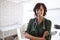 Portrait Of Smiling Female Doctor With Stethoscope Standing By Desk In Office