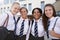 Portrait Of Smiling Female High School Students Wearing Uniform Outside College Building