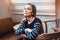 Portrait of smiling female hipster waiting for meeting with best friend while during coffee break in cafe. Grey