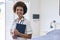 Portrait Of Smiling Female Nurse Wearing Uniform With Digital Tablet In Private Hospital Room