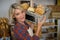 Portrait of smiling female staff carrying wicker basket of various breads at counter