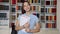 Portrait of smiling female teenage schoolgirl looking at camera, library interior background