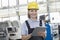 Portrait of smiling female worker using digital tablet in manufacturing industry