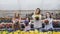 Portrait of smiling four girls stretching synchronously flower pots to camera