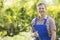 Portrait of smiling gardener holding rake in plant nursery