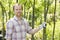 Portrait of smiling gardener standing at plant nursery