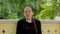 Portrait of a smiling girl with braid dressed in black sitting in the gazebo