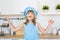 Portrait of smiling girl in cook clothes funs with bunch onion on a kitchen