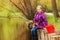 Portrait of smiling girl fishing near pond