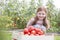 Portrait of smiling girl with fresh organic tomatoes in crate at farm