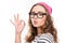 Portrait of smiling girl in hat and glasses gesturing `OK` and pouting