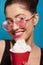 Portrait of smiling girl keeping red can with whipped cream.