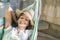 Portrait of a smiling girl laying in a hammock with straw hat summer image of relaxation and joy