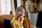 Portrait of a smiling girl in a yellow dress 6 years old. Pierced ear.Blue eyes, long hair.