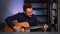 Portrait of smiling guitarist singer male playing acoustic guitar and singing song looking at camera