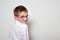 Portrait of a smiling handsome boy in large round glasses. White background