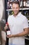 Portrait of a smiling handsome showing a wine bottle