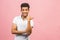 Portrait of a smiling happy african man in casual pointing with fingers aside isolated over pink background